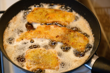 Close-up on frying cutlets in a pan.
