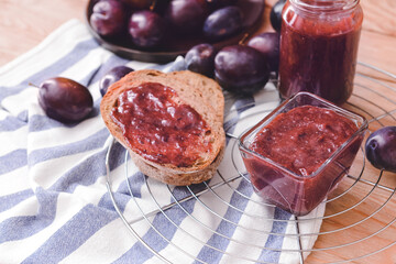 Composition with delicious homemade plum jam on wooden background