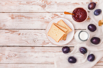 Composition with delicious homemade plum jam on wooden background