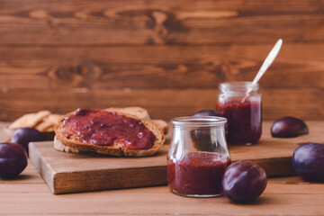 Composition with delicious homemade plum jam on wooden background