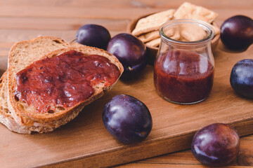 Composition with delicious homemade plum jam on wooden background