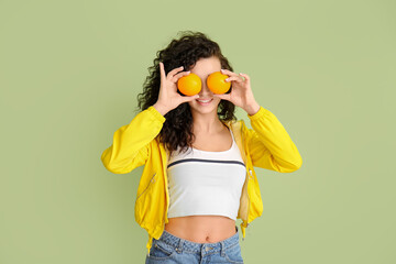 Portrait of stylish young woman with orange fruit on color background