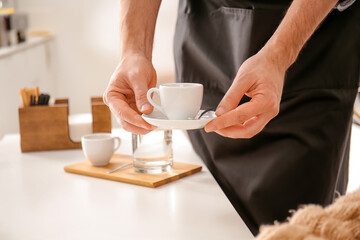 Barista bringing hot espresso for visitor in cafe