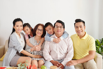 Portrait of happy big Vietnamese family gathered at home for dinner