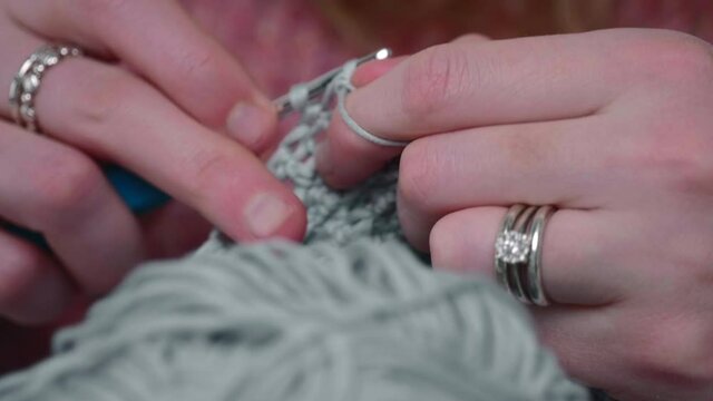 Woman Doing Handmade Crocheting Creation In Gray Yarn. - Rack Focus Shot