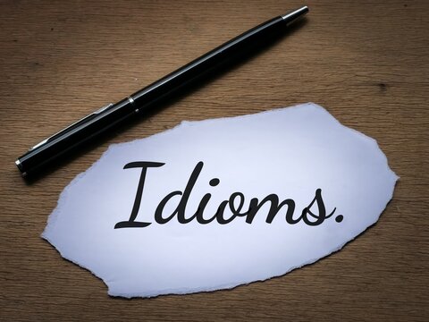 Selective focus top view text Idioms written on a piece of paper with a pen. 