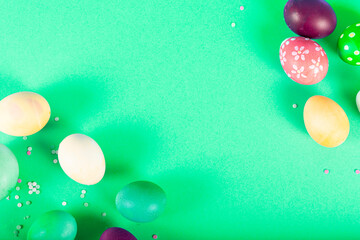 Colorful background with Easter eggs on green background. Happy Easter concept. Can be used as poster, background, holiday card. Flat lay, top view, copy space. Studio Photo