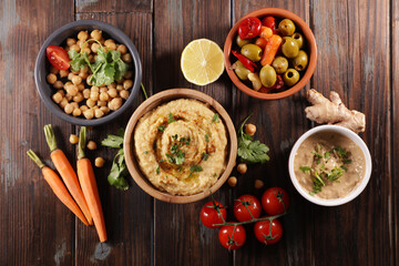 hummus with fresh vegetable on wood background