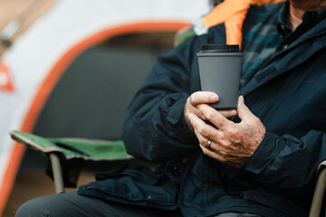 Senior man holding gray reusable cup