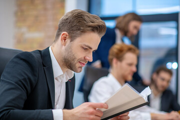Attentive man in suit reading document