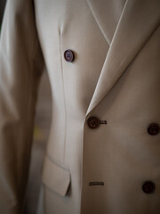 Close up of beige suit jacket with tuxedo white shirt and vintage bow detail