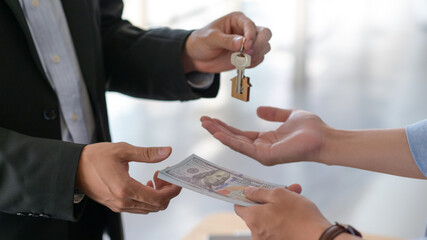 Cropped shot of Exchange of dollars and house keys between buyer and seller.