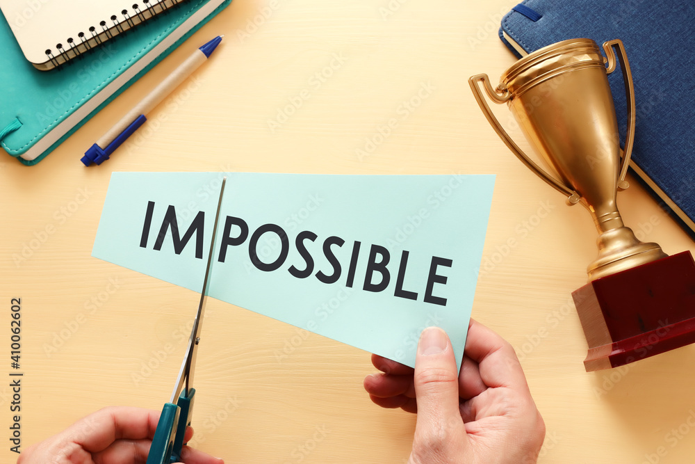 Poster man hand holding card with the text impossible, cutting the word im so it written possible. success 