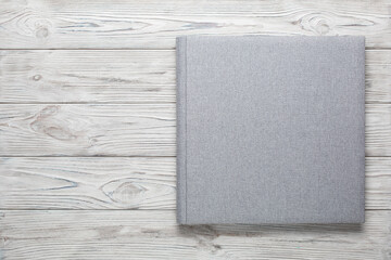 family photo book with grey fabric cover. stylish wedding photo album on wooden background with...