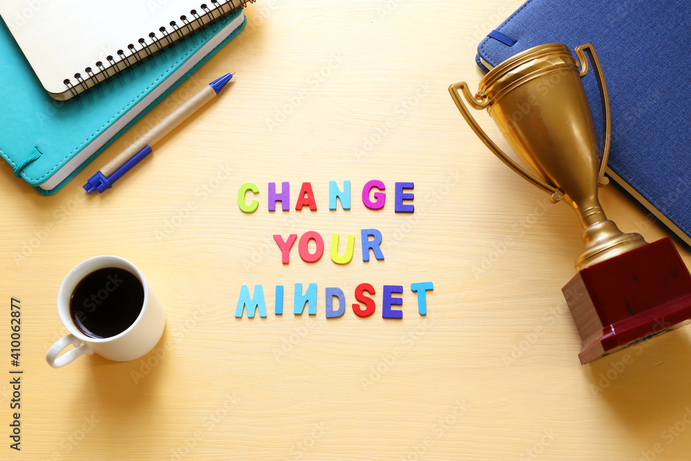 Poster concept image with change your mindset text. top view of office table