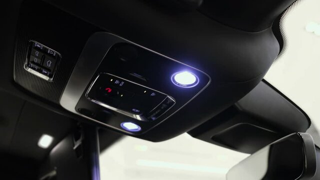 Driver and front passenger lighting control panel and other control buttons on the ceiling of the new luxury car
