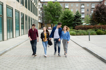 Friendship, travel and vacation concept - group of smiling friends walking in the city