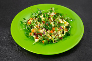 Vitamin salad on a green plate.