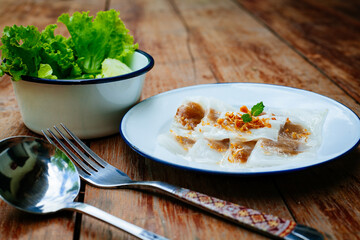 Selective focus of Thai steamed rice-skin dumplings or khao kriap pak maw is tow popular and unique Thai street food snacks ,
thai style dessert on wooden