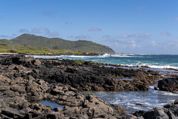 Fototapeta na wymiar Sandy Beach with Makapuu Point Lighthouse trail in the background.
