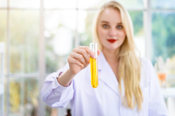 Close-up of a female researcher carrying out research in a chemistry lab scientist holding test tube with sample in Laboratory analysis background