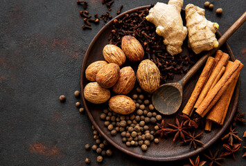 Gingerbread spices on slate - star anise, cinnamon, cloves, nutmeg, ginger, cardamom, black pepper