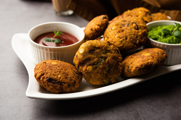 Parippu or Paruppu Vadai or Masala Chana Dal Vada served in a plate with ketchup