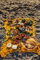 Beach picnic with turkish dishes on a yellow blanket