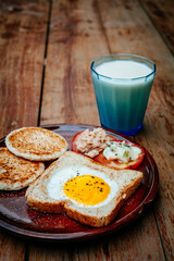 Fototapeta na wymiar English breakfast - fried egg, beans, tomatoes, mushrooms, bacon and toast