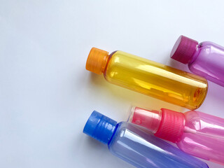 Colorful plastic travel bottles. Small containers for liquids like shower gel and shampoo. Face and body care products in compact size.