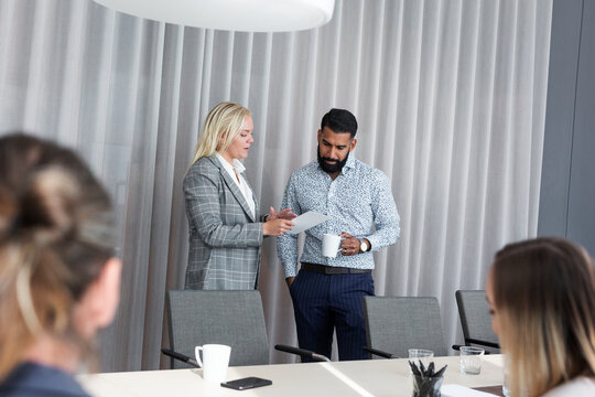 Coworkers talking in boardroom