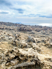 Sand with holes on the seashore. Sandy rocks on the beach of Mediterranean sea. Rough surface background.