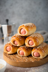 Homemade sausages in dough on a wooden board, fast food, close-up