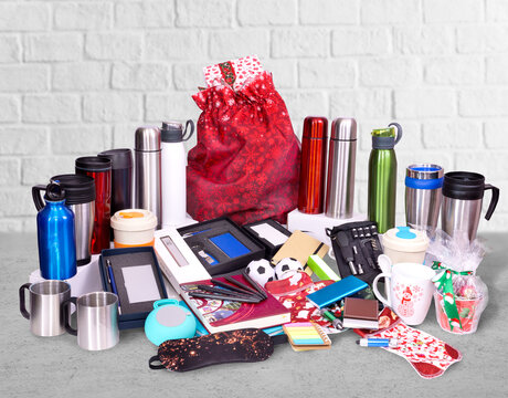 Composition of different promo products - Thermo mug, mug, gifts, sleep mask, power bank, pens in boxes, notebooks, tools, sticky.