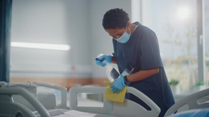 Hospital Ward: Professional Black Nurse Wearing Face Mask, Wiping the Bed, Cleaning Room After Covid-19 Patients Recover. Disinfection, Sterilizing, Sanitizing Clinic after Coronavirus Infected People - Powered by Adobe