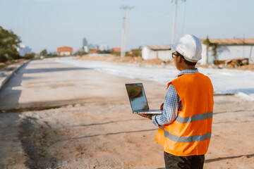 Civil engineer at construction site using computer laptop checking work. Management in the...