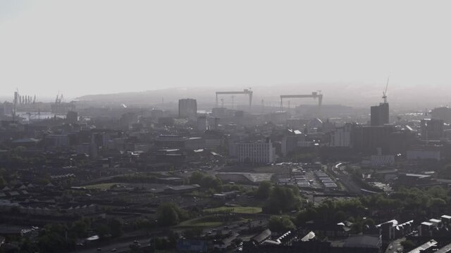 Aerial flyover of west Belfast from the countryside looking towards the city centre or center