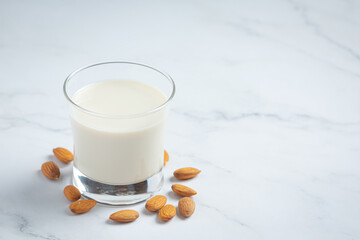 Almond milk with almond on marble background