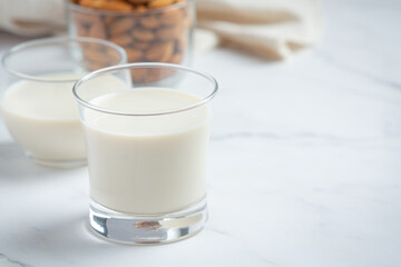 Almond milk with almond on marble background