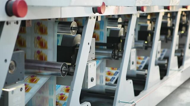 Long Metallic Body of Servo Automated Print Labeling Machine with Turning Cylindrical Rollers and Drums on Sheet of Paper