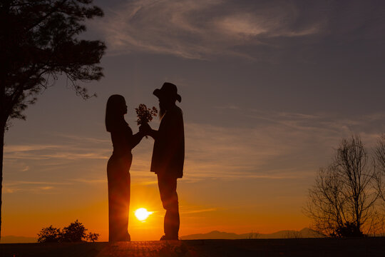 Young couple enjoying the sunset in the mountain