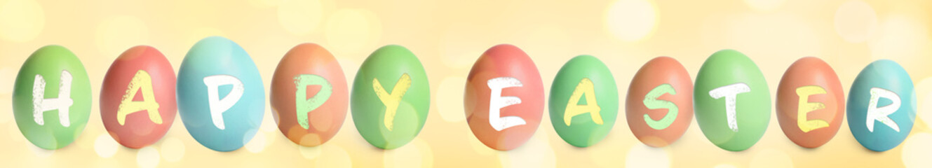 Fototapeta premium Happy Easter. Colorful dyed eggs on yellow background, banner design