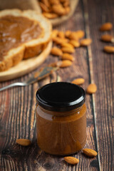Raw Organic Almond Butter on dark wood background