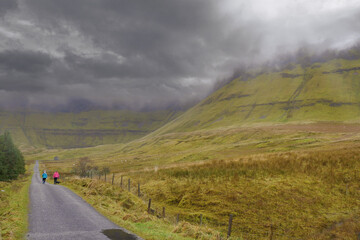 Two women walking on a road with beautiful scenery around them. Gleniff Horseshoe drive loop county Sligo, Ireland