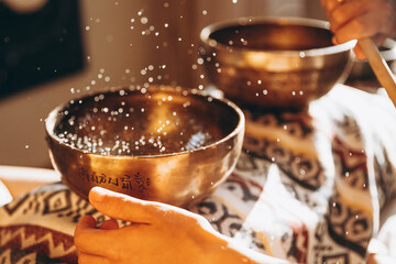 Nepal Buddha copper singing bowl at spa salon. Young bearded man doing massage therapy singing...