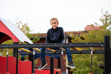 Boy sitting on monkey bars