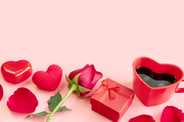 Fototapeta na wymiar Pastel pink background with red hearts, gifts, heart shaped cup of coffee and rose. Valentine Day, anniversary and birthday concept. Flat lay, closeup and copy space