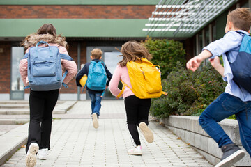 Rear view of schoolchildren running