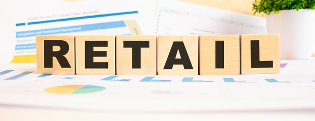 RETAIL word on wooden cubes. The background is a business graphs. Business and finance concept