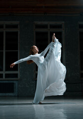 girl pulls her leg up in a white dress, dance from a beautiful girl, contemporary, stretching, ballet